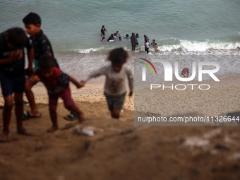 Displaced Palestinians are enjoying swimming in Deir el-Balah, in the central Gaza Strip, on June 13, 2024, amid the ongoing conflict in the...