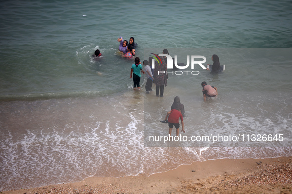 Displaced Palestinians are enjoying swimming in Deir el-Balah, in the central Gaza Strip, on June 13, 2024, amid the ongoing conflict in the...