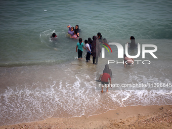 Displaced Palestinians are enjoying swimming in Deir el-Balah, in the central Gaza Strip, on June 13, 2024, amid the ongoing conflict in the...