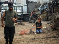 Displaced Palestinian children are sitting in front of their tent in Deir el-Balah, in the central Gaza Strip, on June 13, 2024, amid the on...