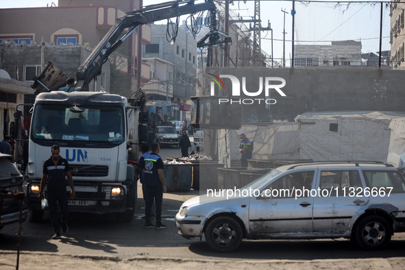 United Nations Agency for Palestinian Refugees (UNRWA) workers are cleaning a street in Deir el-Balah, in the central Gaza Strip, on June 13...