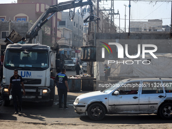 United Nations Agency for Palestinian Refugees (UNRWA) workers are cleaning a street in Deir el-Balah, in the central Gaza Strip, on June 13...