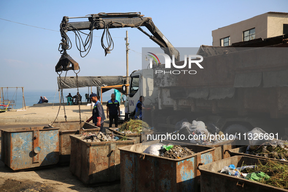 United Nations Agency for Palestinian Refugees (UNRWA) workers are cleaning a street in Deir el-Balah, in the central Gaza Strip, on June 13...