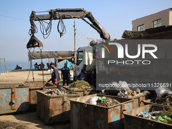 United Nations Agency for Palestinian Refugees (UNRWA) workers are cleaning a street in Deir el-Balah, in the central Gaza Strip, on June 13...