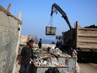 United Nations Agency for Palestinian Refugees (UNRWA) workers are cleaning a street in Deir el-Balah, in the central Gaza Strip, on June 13...