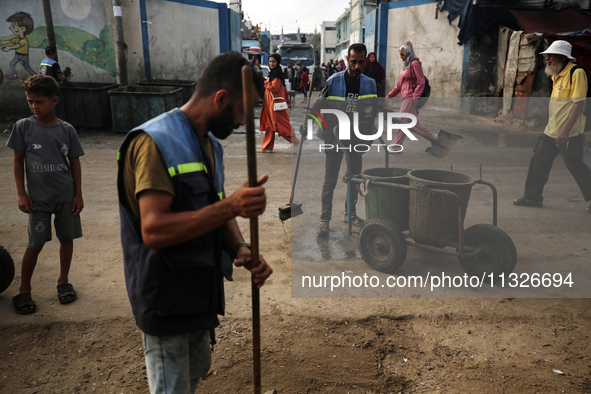 United Nations Agency for Palestinian Refugees (UNRWA) workers are cleaning a street in Deir el-Balah, in the central Gaza Strip, on June 13...