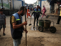 United Nations Agency for Palestinian Refugees (UNRWA) workers are cleaning a street in Deir el-Balah, in the central Gaza Strip, on June 13...