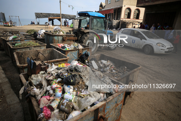 United Nations Agency for Palestinian Refugees (UNRWA) workers are cleaning a street in Deir el-Balah, in the central Gaza Strip, on June 13...