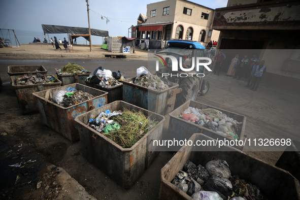 United Nations Agency for Palestinian Refugees (UNRWA) workers are cleaning a street in Deir el-Balah, in the central Gaza Strip, on June 13...