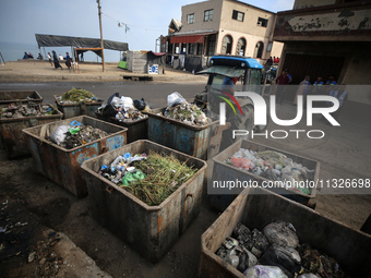 United Nations Agency for Palestinian Refugees (UNRWA) workers are cleaning a street in Deir el-Balah, in the central Gaza Strip, on June 13...