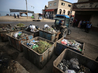 United Nations Agency for Palestinian Refugees (UNRWA) workers are cleaning a street in Deir el-Balah, in the central Gaza Strip, on June 13...