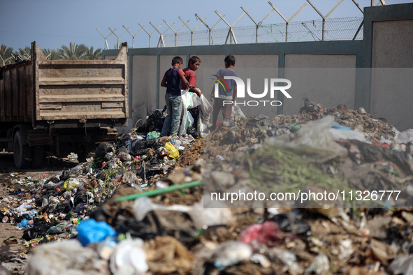 Displaced Palestinian children are searching for recyclables at a garbage dump in Deir el-Balah, in the central Gaza Strip, on June 13, 2024...