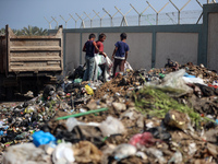 Displaced Palestinian children are searching for recyclables at a garbage dump in Deir el-Balah, in the central Gaza Strip, on June 13, 2024...