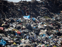 A Palestinian boy is searching for recyclables at a garbage dump in Deir el-Balah, in the central Gaza Strip, on June 13, 2024, amid the ong...