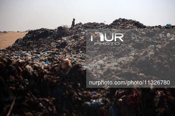 A Palestinian boy is searching for recyclables at a garbage dump in Deir el-Balah, in the central Gaza Strip, on June 13, 2024, amid the ong...