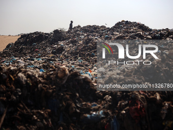 A Palestinian boy is searching for recyclables at a garbage dump in Deir el-Balah, in the central Gaza Strip, on June 13, 2024, amid the ong...