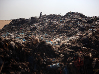 A Palestinian boy is searching for recyclables at a garbage dump in Deir el-Balah, in the central Gaza Strip, on June 13, 2024, amid the ong...