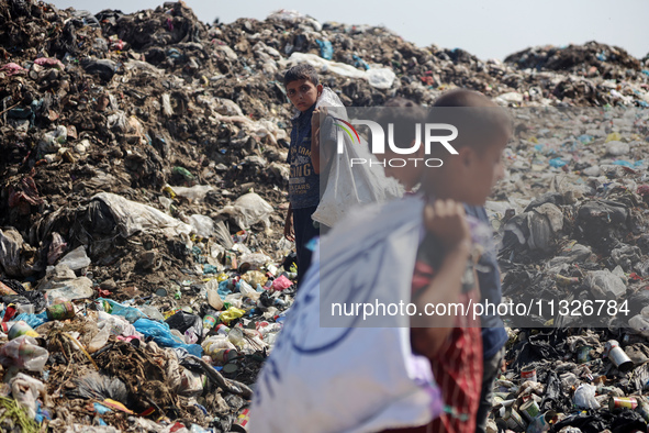 Displaced Palestinian children are searching for recyclables at a garbage dump in Deir el-Balah, in the central Gaza Strip, on June 13, 2024...