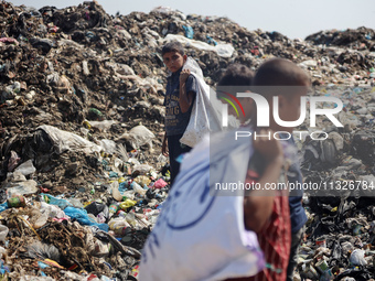 Displaced Palestinian children are searching for recyclables at a garbage dump in Deir el-Balah, in the central Gaza Strip, on June 13, 2024...