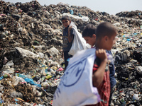 Displaced Palestinian children are searching for recyclables at a garbage dump in Deir el-Balah, in the central Gaza Strip, on June 13, 2024...