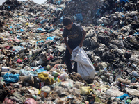 A Palestinian boy is searching for recyclables at a garbage dump in Deir el-Balah, in the central Gaza Strip, on June 13, 2024, amid the ong...