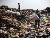 Displaced Palestinian children are searching for recyclables at a garbage dump in Deir el-Balah, in the central Gaza Strip, on June 13, 2024...