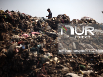 A Palestinian boy is searching for recyclables at a garbage dump in Deir el-Balah, in the central Gaza Strip, on June 13, 2024, amid the ong...