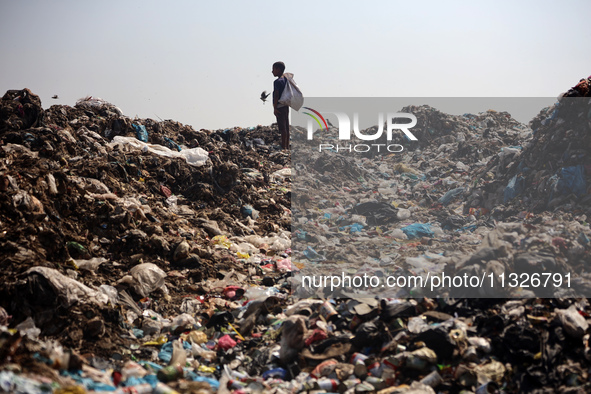 A Palestinian boy is searching for recyclables at a garbage dump in Deir el-Balah, in the central Gaza Strip, on June 13, 2024, amid the ong...