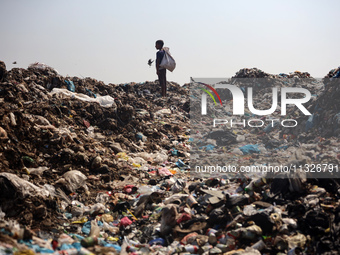 A Palestinian boy is searching for recyclables at a garbage dump in Deir el-Balah, in the central Gaza Strip, on June 13, 2024, amid the ong...