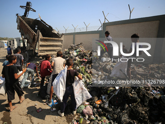 Displaced Palestinian children are searching for recyclables at a garbage dump in Deir el-Balah, in the central Gaza Strip, on June 13, 2024...