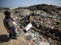 Displaced Palestinian children are searching for recyclables at a garbage dump in Deir el-Balah, in the central Gaza Strip, on June 13, 2024...