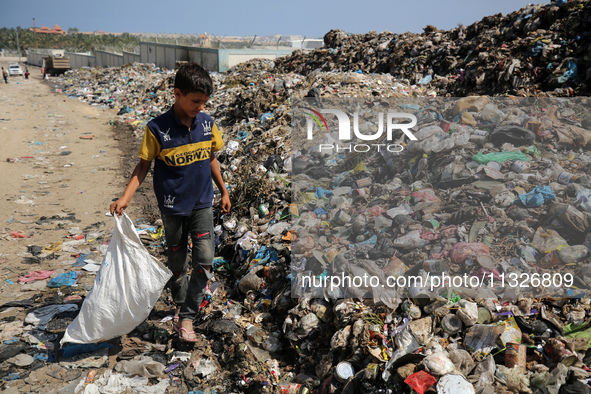 A Palestinian boy is searching for recyclables at a garbage dump in Deir el-Balah, in the central Gaza Strip, on June 13, 2024, amid the ong...