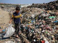 A Palestinian boy is searching for recyclables at a garbage dump in Deir el-Balah, in the central Gaza Strip, on June 13, 2024, amid the ong...