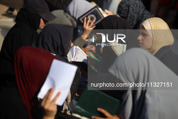 Palestinian women are reciting from memory the entire Koran, Islam's holy book, in one sitting at a camp for displaced people in Deir el-Bal...