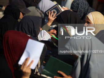 Palestinian women are reciting from memory the entire Koran, Islam's holy book, in one sitting at a camp for displaced people in Deir el-Bal...