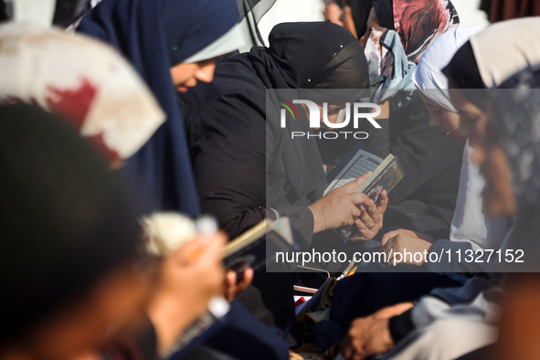 Palestinian women are reciting from memory the entire Koran, Islam's holy book, in one sitting at a camp for displaced people in Deir el-Bal...