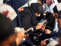 Palestinian women are reciting from memory the entire Koran, Islam's holy book, in one sitting at a camp for displaced people in Deir el-Bal...