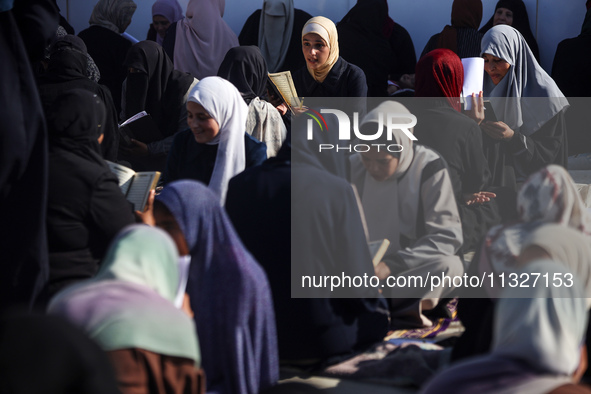 Palestinian women are reciting from memory the entire Koran, Islam's holy book, in one sitting at a camp for displaced people in Deir el-Bal...