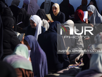 Palestinian women are reciting from memory the entire Koran, Islam's holy book, in one sitting at a camp for displaced people in Deir el-Bal...