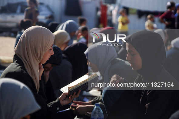 Palestinian women are reciting from memory the entire Koran, Islam's holy book, in one sitting at a camp for displaced people in Deir el-Bal...