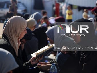 Palestinian women are reciting from memory the entire Koran, Islam's holy book, in one sitting at a camp for displaced people in Deir el-Bal...