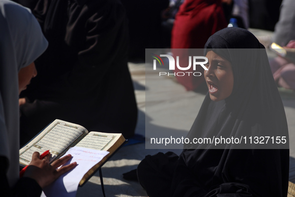 Palestinian women are reciting from memory the entire Koran, Islam's holy book, in one sitting at a camp for displaced people in Deir el-Bal...