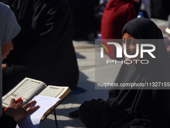 Palestinian women are reciting from memory the entire Koran, Islam's holy book, in one sitting at a camp for displaced people in Deir el-Bal...