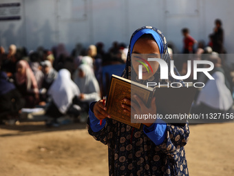 Palestinian women are reciting from memory the entire Koran, Islam's holy book, in one sitting at a camp for displaced people in Deir el-Bal...