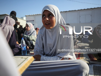 Palestinian women are reciting from memory the entire Koran, Islam's holy book, in one sitting at a camp for displaced people in Deir el-Bal...