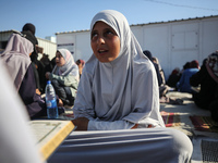 Palestinian women are reciting from memory the entire Koran, Islam's holy book, in one sitting at a camp for displaced people in Deir el-Bal...