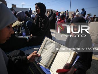 Palestinian women are reciting from memory the entire Koran, Islam's holy book, in one sitting at a camp for displaced people in Deir el-Bal...