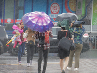 Pedestrians are walking under umbrellas during heavy rain, which is amounting to half of the monthly average, in Kyiv, Ukraine, on June 12,...