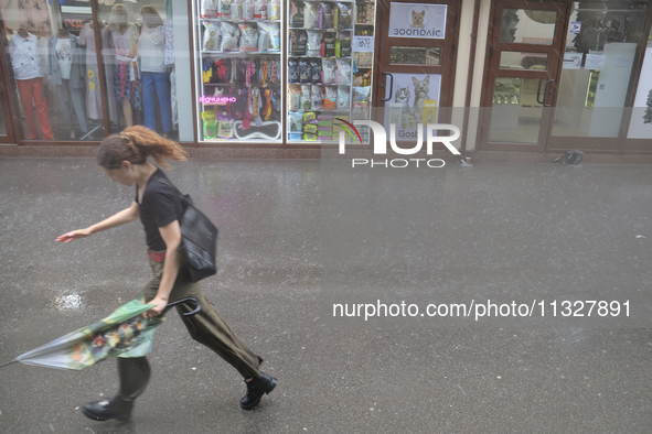 A woman is running under heavy rain, which is amounting to half of the monthly average, in Kyiv, Ukraine, on June 12, 2024. 