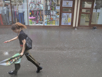 A woman is running under heavy rain, which is amounting to half of the monthly average, in Kyiv, Ukraine, on June 12, 2024. (